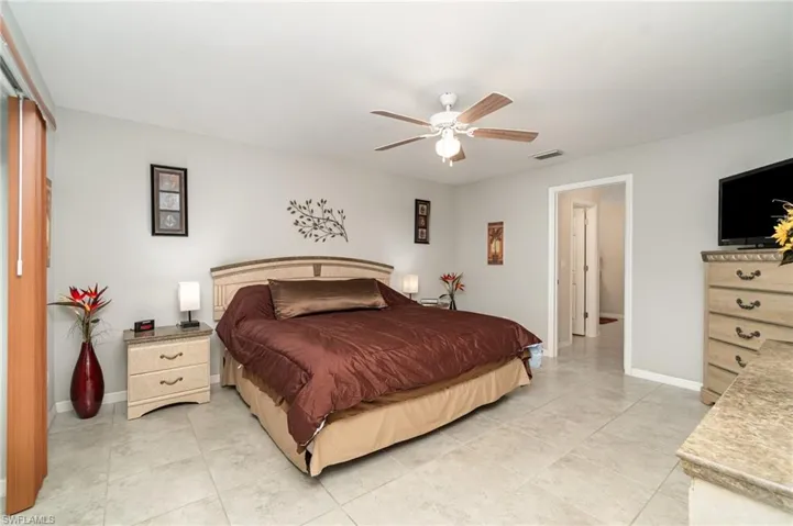 Large primary bedroom with sliders to the lanai and 2 walk in closets.