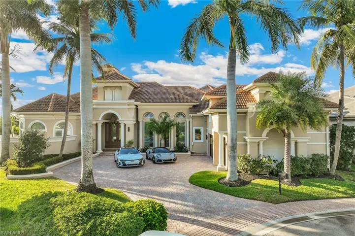 View of front of home with curved driveway, a tiled roof, and stucco siding