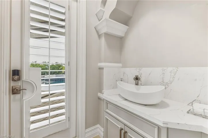 Bathroom with vanity and tasteful backsplash