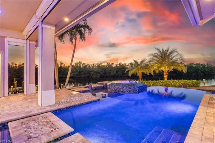 Outdoor pool featuring an in-ground hot tub and a patio