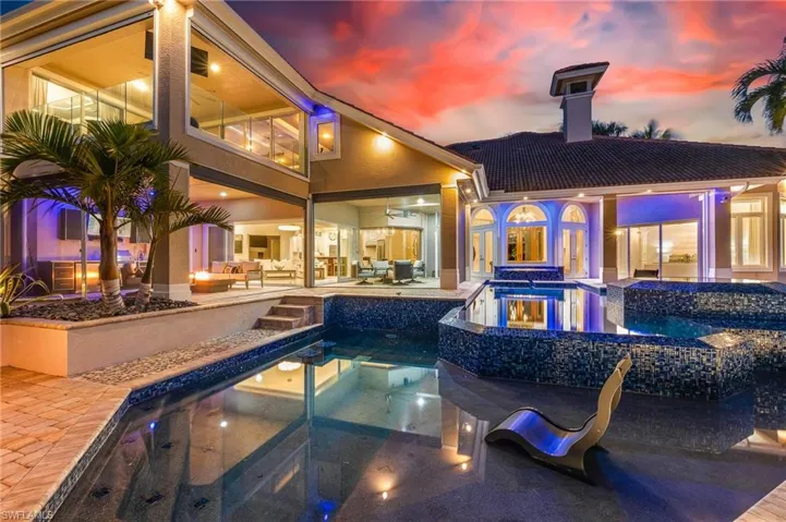 View of swimming pool with a patio area, a pool with connected hot tub, and an outdoor living space
