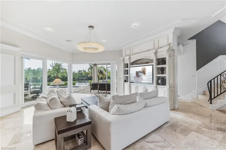 Living area with stairway and crown molding