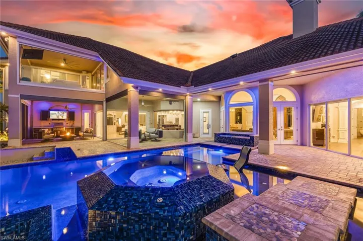 Pool at dusk featuring an outdoor pool, an in-ground hot tub, a patio area, and outdoor lounge area