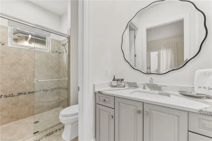 Full bath with a shower stall, vanity, and light tile patterned floors
