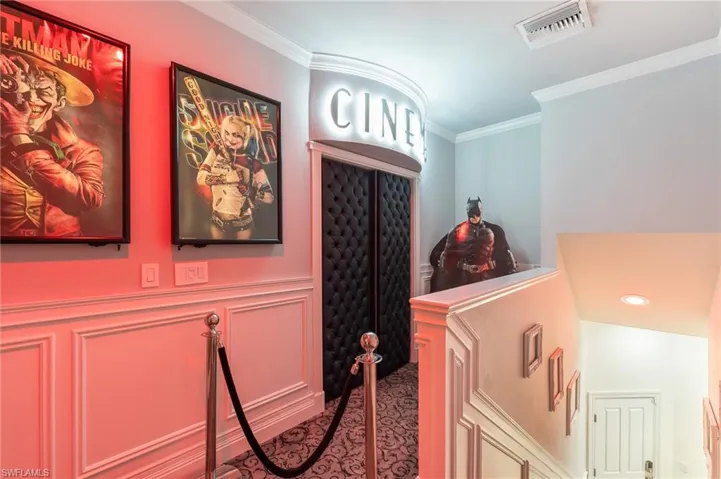 Corridor featuring ornamental molding, a decorative wall, and wainscoting