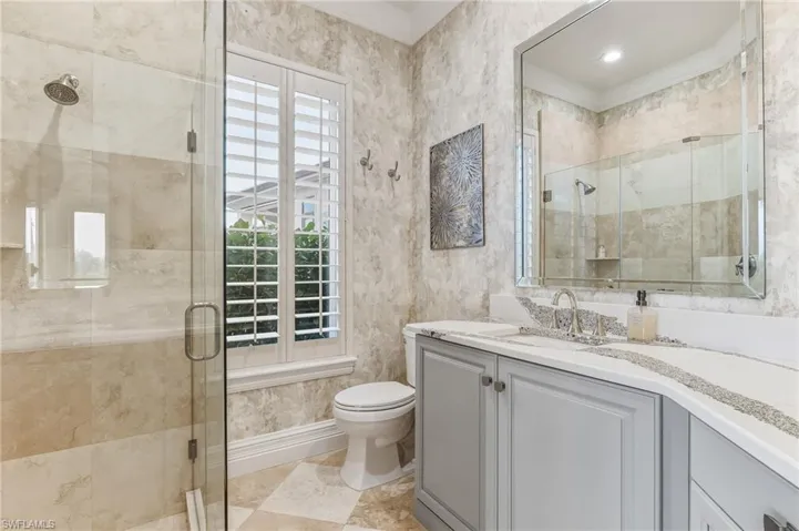 Bathroom featuring vanity, a stall shower, and ornamental molding