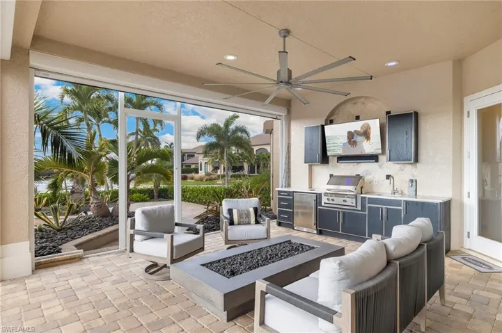 View of patio featuring an outdoor living space with a fire pit, a ceiling fan, and an outdoor kitchen