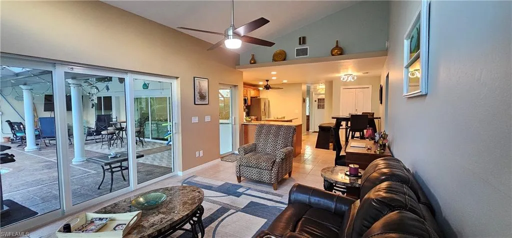 Tiled living room with high vaulted ceiling and ceiling fan