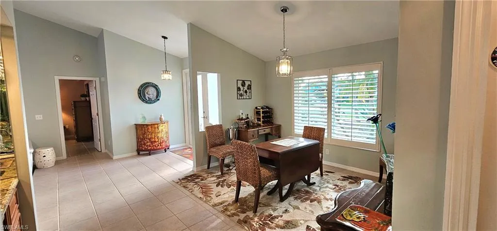 Dining area with lofted ceiling and light tile patterned floors