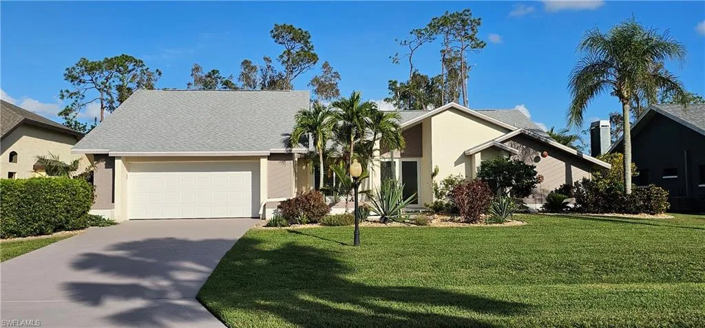 View of front of home with a garage and a front lawn