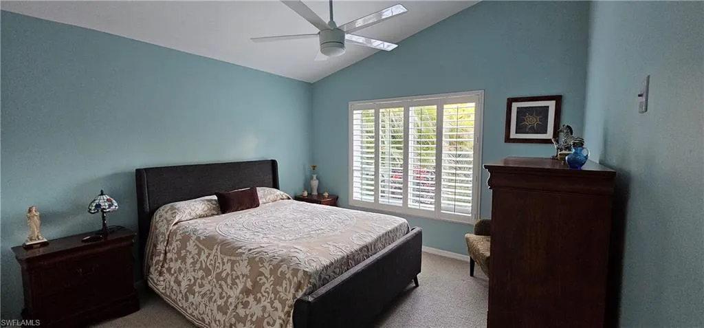 Bedroom featuring high vaulted ceiling, light carpet, and ceiling fan
