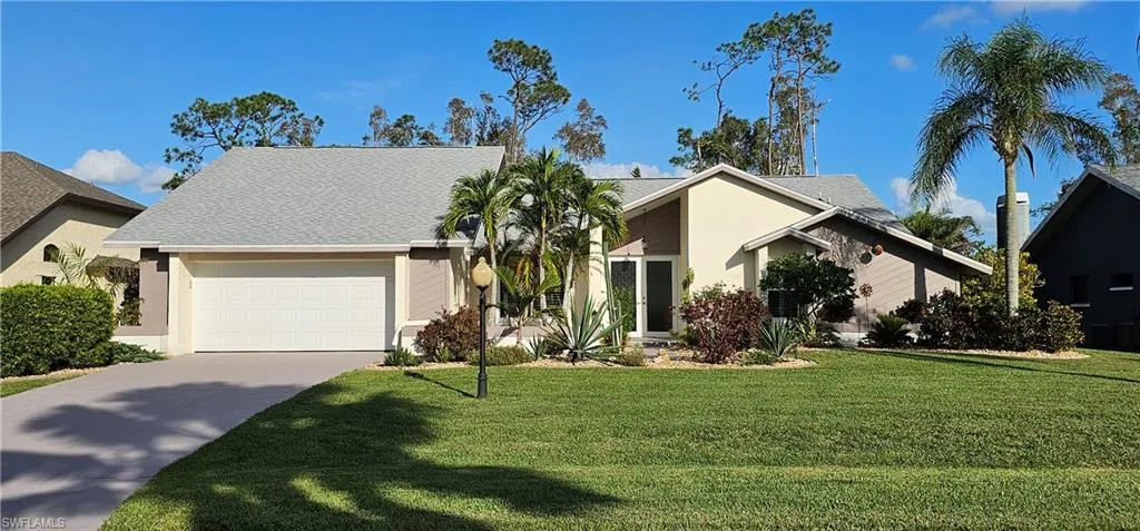 View of front facade with a front lawn and a garage
