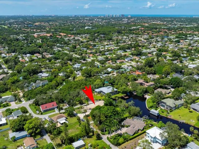 Aerial view of property's location with a nearby body of water and nearby suburban area