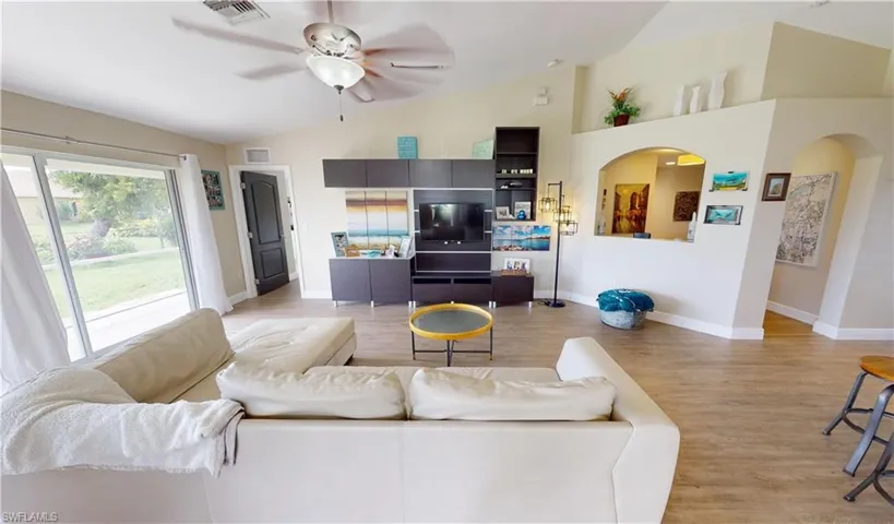 Living room featuring lofted ceiling, light wood-type flooring, and ceiling fan
