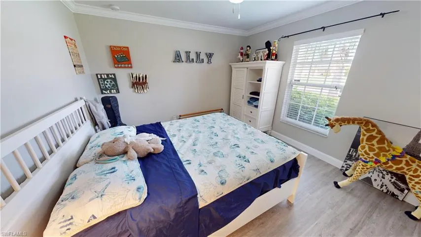 Bedroom with wood-type flooring and crown molding