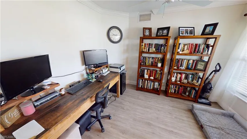Office area with light hardwood / wood-style floors, ornamental molding, and ceiling fan
