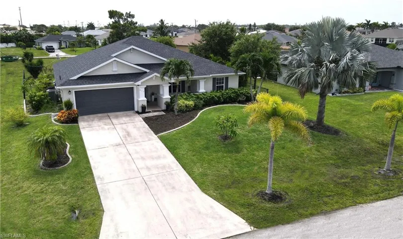 View of front of house with a garage and a front yard