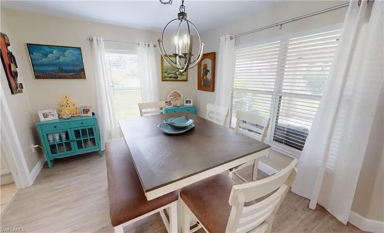 Dining area featuring an inviting chandelier, light hardwood / wood-style flooring, and a healthy amount of sunlight
