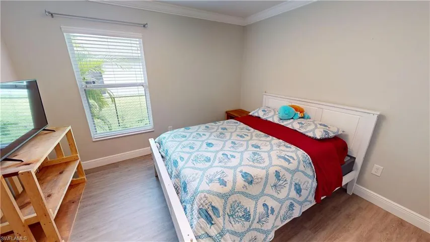 Bedroom featuring ornamental molding and wood-type flooring
