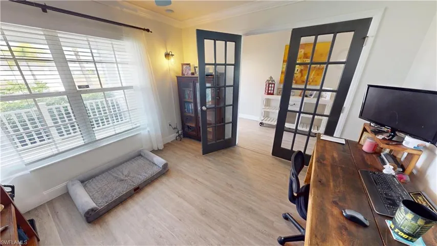Home office with hardwood / wood-style flooring and crown molding