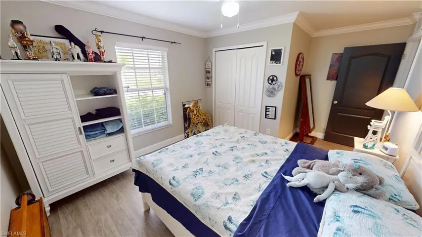 Bedroom featuring ornamental molding, a closet, hardwood / wood-style flooring, and ceiling fan