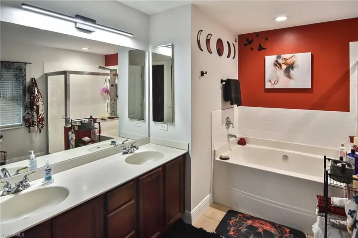 Bathroom featuring tile patterned floors, independent shower and bath, and double sink vanity