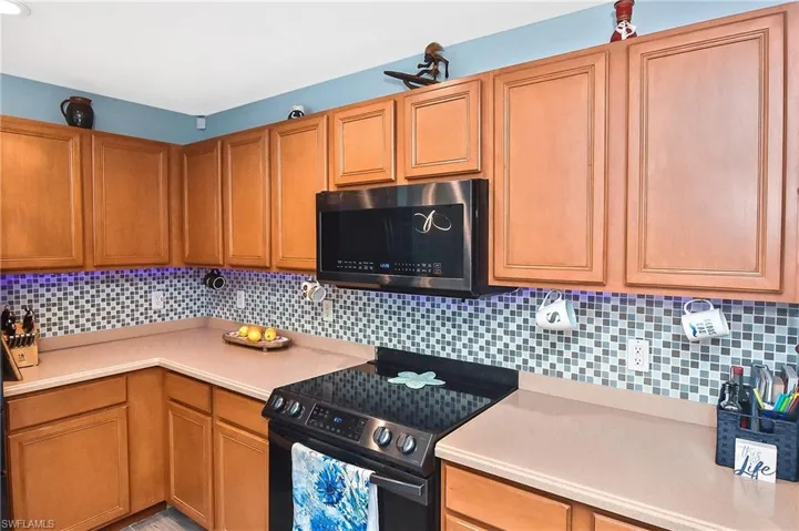 Kitchen with black range with electric stovetop and decorative backsplash