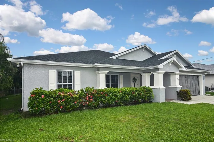 View of front of property with a garage and a front lawn