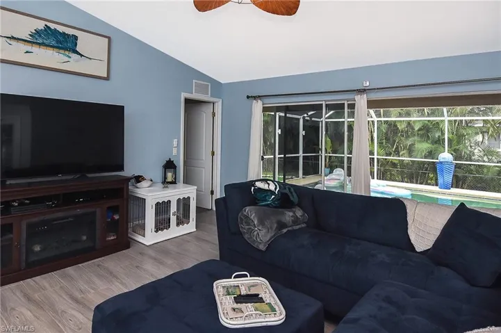 Living room featuring tile style floors, ceiling fan, and vaulted ceiling
