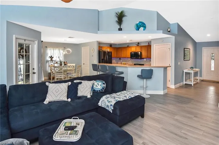 Living room with high vaulted ceiling and light wood-type flooring