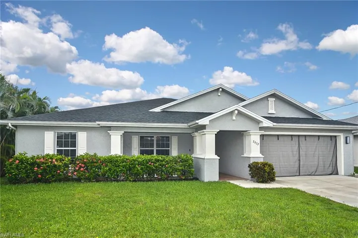 Ranch-style home featuring a garage and a front yard