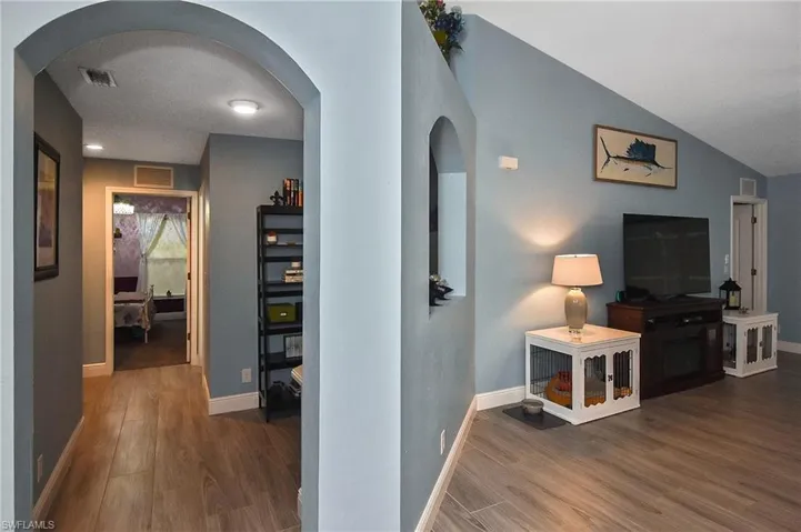 Hallway with tile type flooring and vaulted ceiling