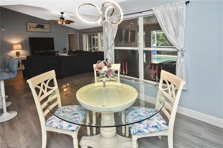 Dining area featuring ceiling fan with notable chandelier and hardwood / wood-style floors