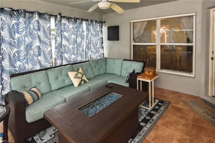 Living room with ceiling fan and tile patterned flooring