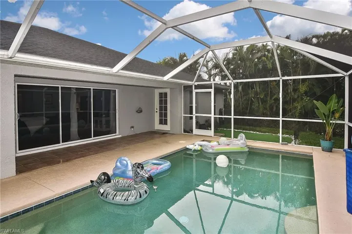 View of swimming pool with a patio and glass enclosure