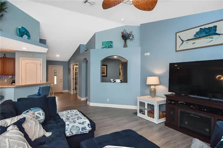 Living room with tile flooring, ceiling fan, and high vaulted ceiling