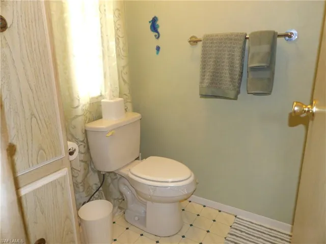 Half bath featuring toilet and baseboards