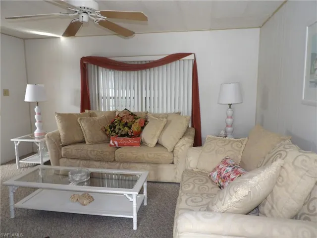 Living area featuring carpet and ceiling fan