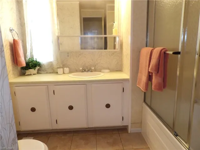 Full bathroom with vanity, combined bath / shower with glass door, and light tile patterned floors