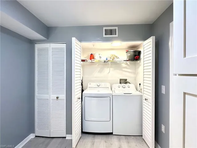 Laundry room with light wood-type flooring and washer and dryer
