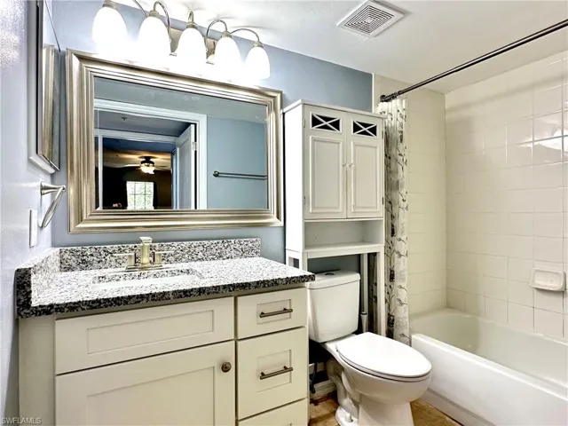 Full bathroom featuring vanity, toilet, and shower / bath combo with shower curtain