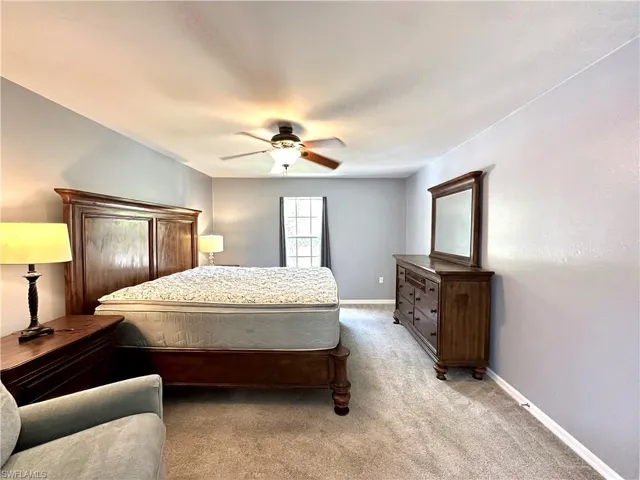Carpeted bedroom featuring ceiling fan