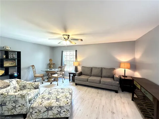 Living room with light hardwood / wood-style flooring and ceiling fan