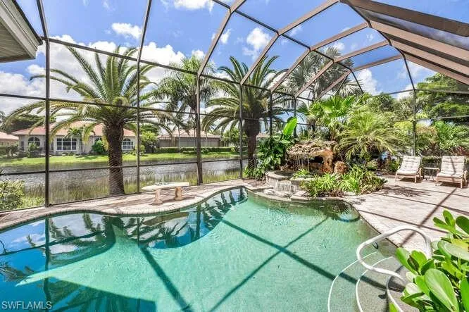 View of pool with a lanai, a water view, and a patio area