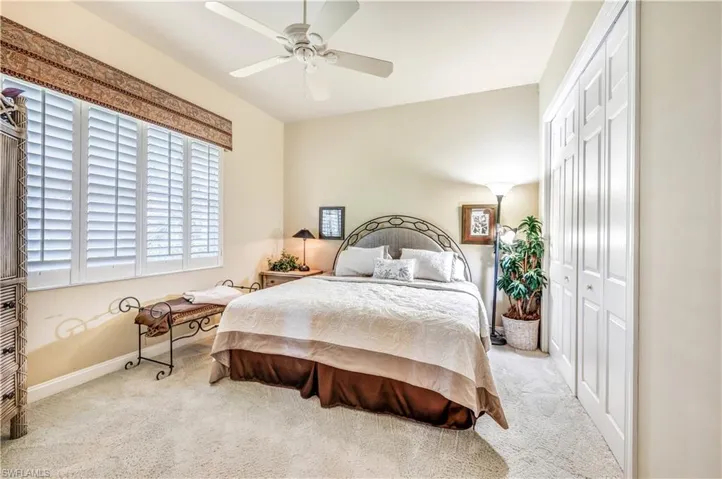 Bedroom featuring a closet, ceiling fan, and light carpet