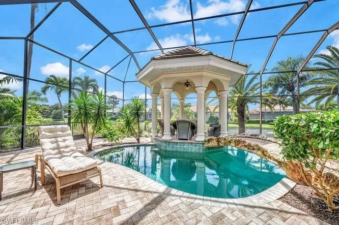 View of swimming pool with a patio and glass enclosure