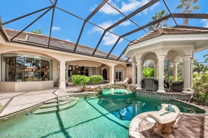 View of swimming pool featuring a patio and glass enclosure