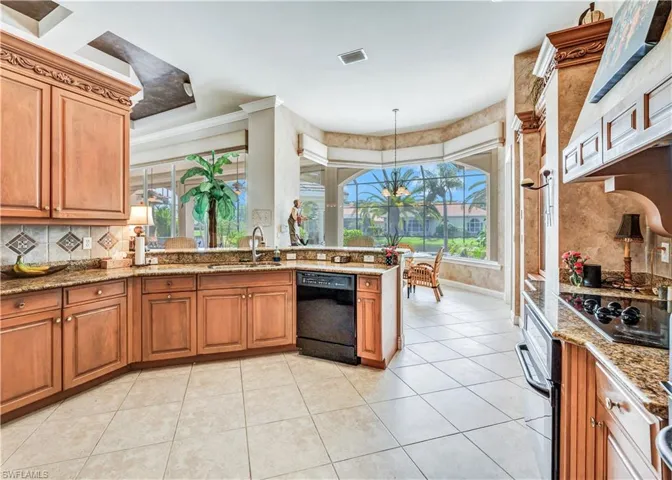 Kitchen featuring black appliances, plenty of natural light, ornamental molding, and sink