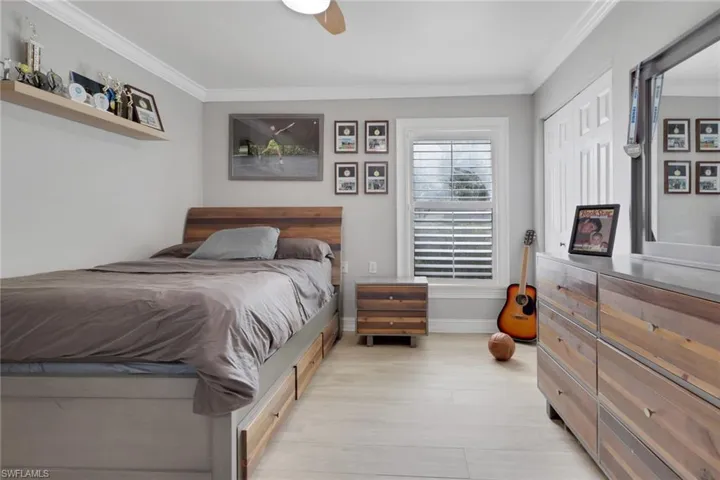 Bedroom featuring crown molding, a ceiling fan, and light wood-type flooring