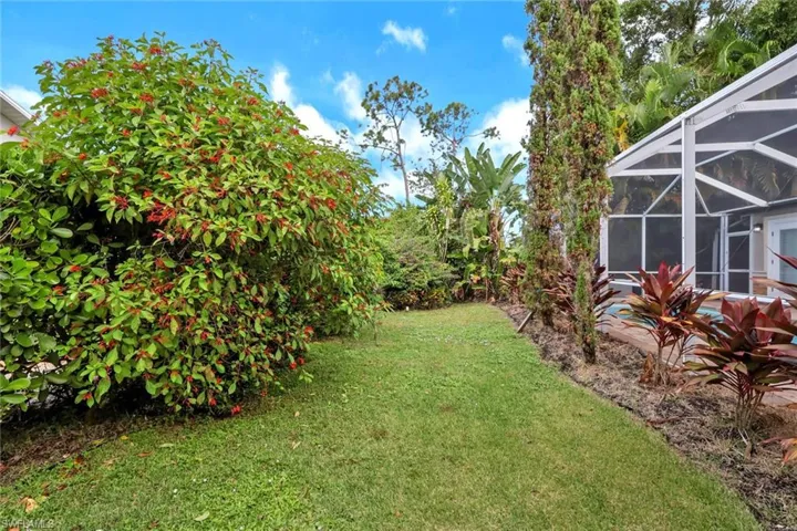 View of green lawn featuring a lanai and a sunroom